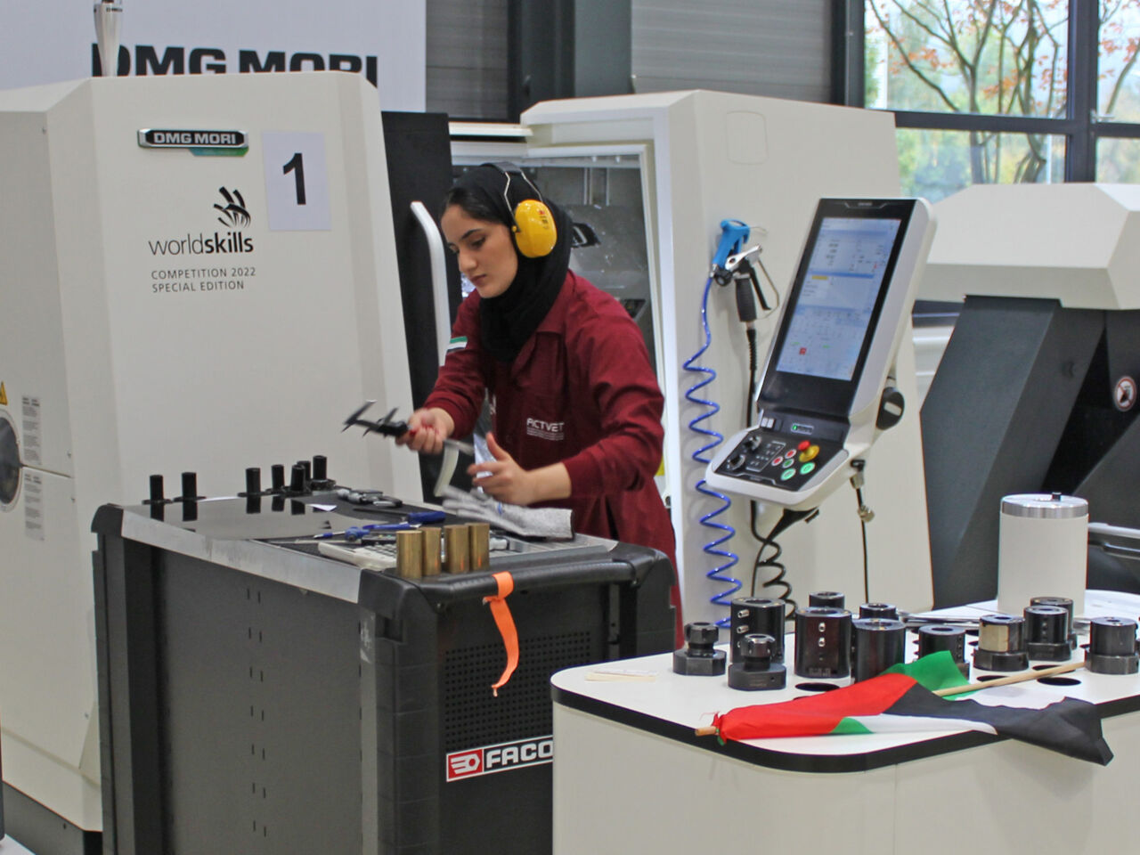 A WorldSkills Competitor standing beside a CNC machine in the DMG MORI’s showroom in Leonberg, Germany.
