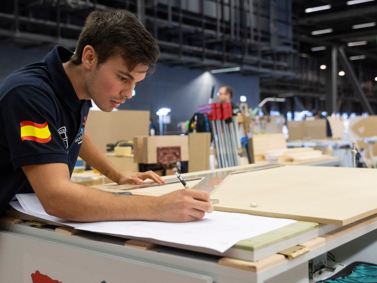 An competitor in WorldSkills Competition 2022 Special Edition annotating plans at Holz, Switzerland’s woodworking sector trade fair, at Messe Basel, Switzerland from 11 to 14 October.
